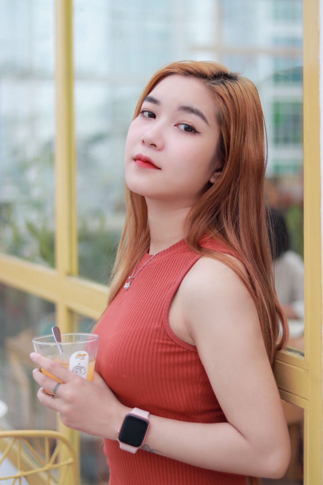 Thai woman in an orange top at a cafe