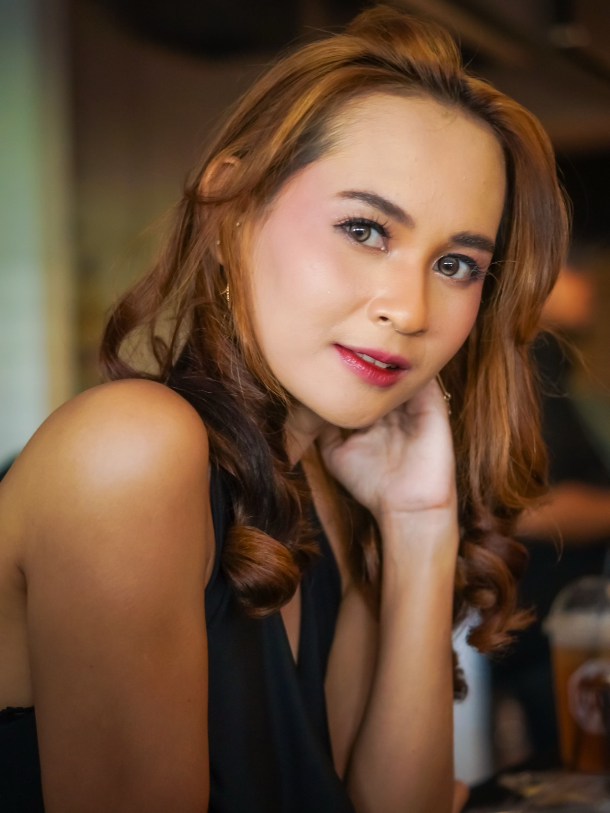 Thai woman with wavy hair in a cafe